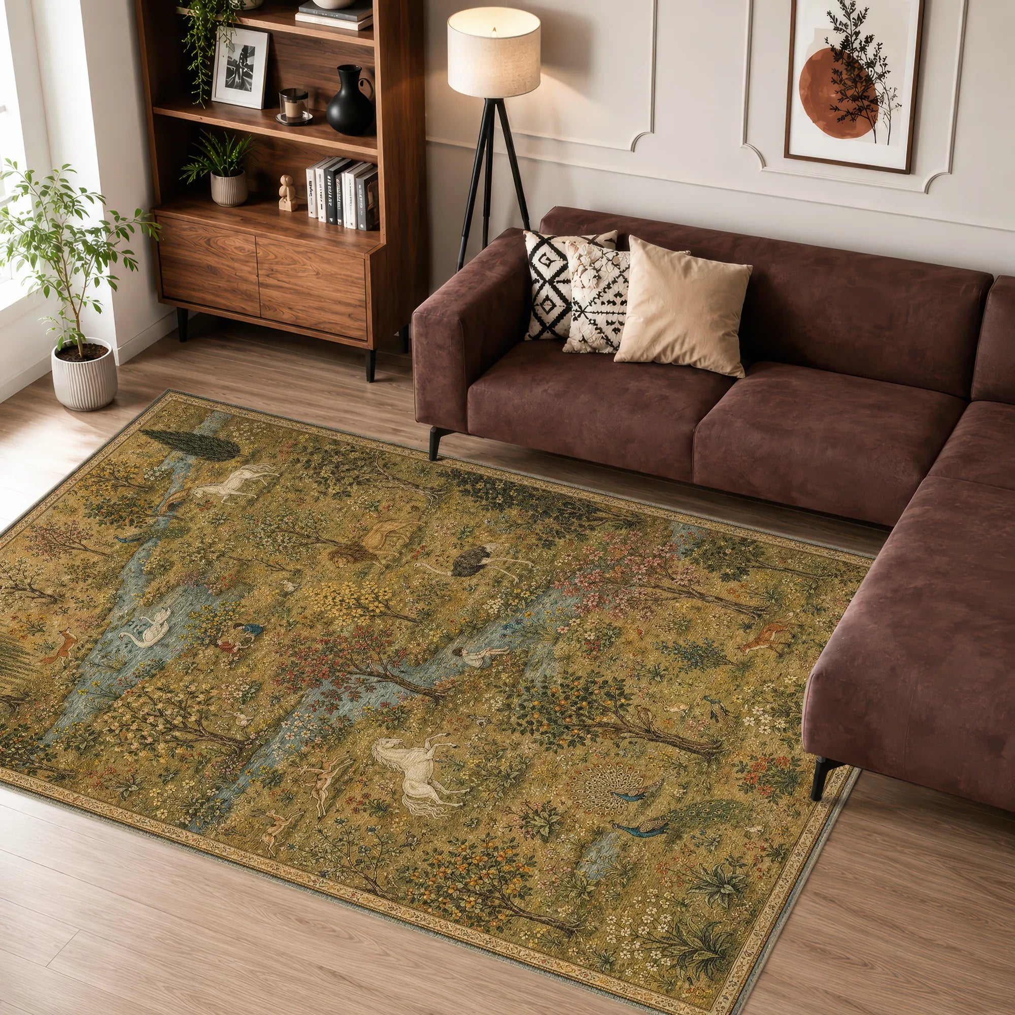 Un tappeto rettangolare con una stampa paesaggistica vintage intricata in tonalità oro tenue, verde oliva e blu, inserito in un soggiorno moderno accanto a un divano angolare marrone.