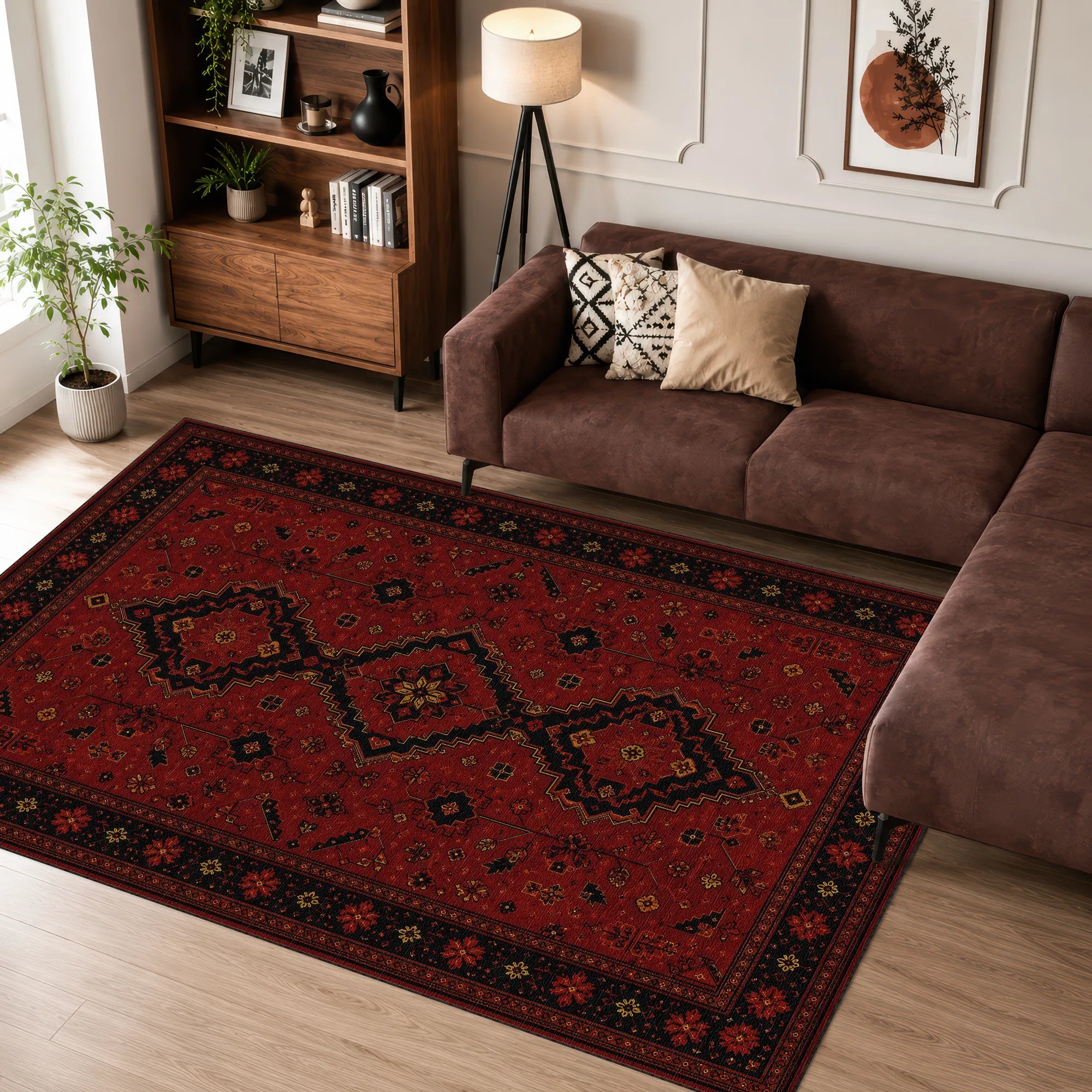 Un grande tappeto rettangolare con un motivo geometrico tradizionale in rosso, nero e beige, posizionato in un soggiorno su un pavimento in legno chiaro accanto a un divano angolare marrone.